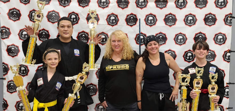 Participants posing in front of tournament banner